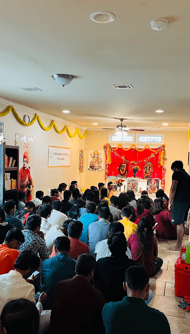 The front room of the Texas A&M house during satsang, students seated before the shrine